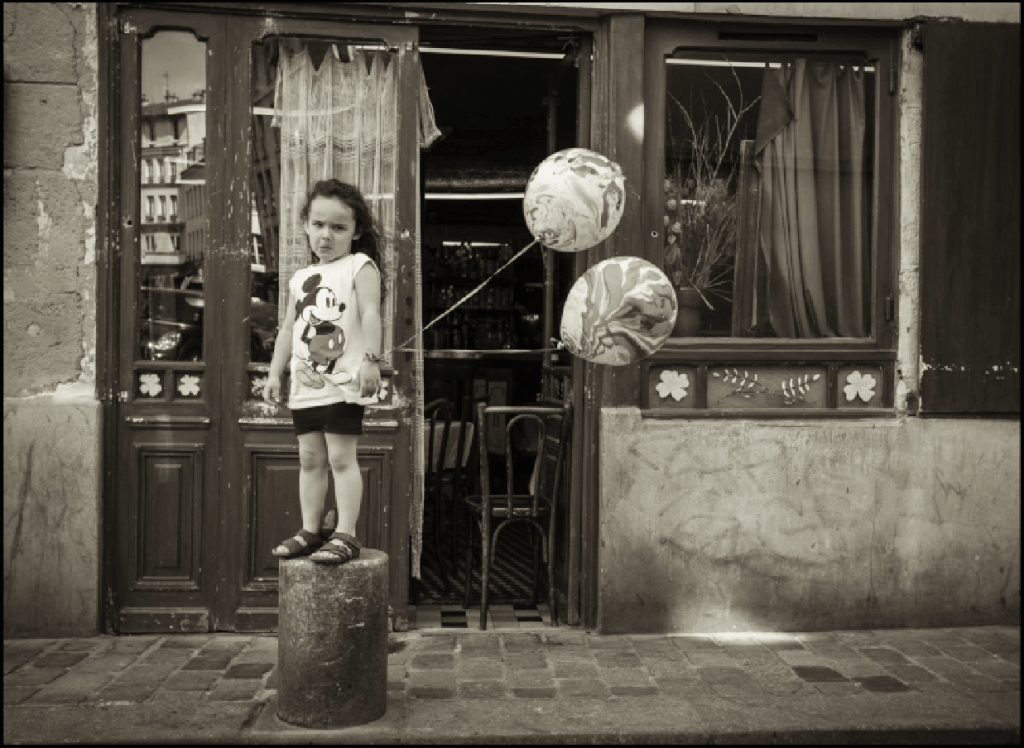 BLACKRAPID Guest Post by Christopher Broughton | Christopher Broughton Photography 7 This little girl was running down the street and jumped up on the pillar with her balloons, full of energy, and turned toward me. When the camera was seen... you get it.